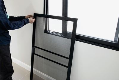 Man standing by window on wall