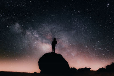 A person standing looking at the star field and the milky way