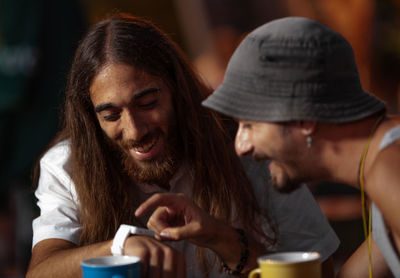 Smiling friends operating smart watch