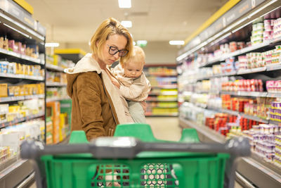 Portrait of young woman standing in supermarket