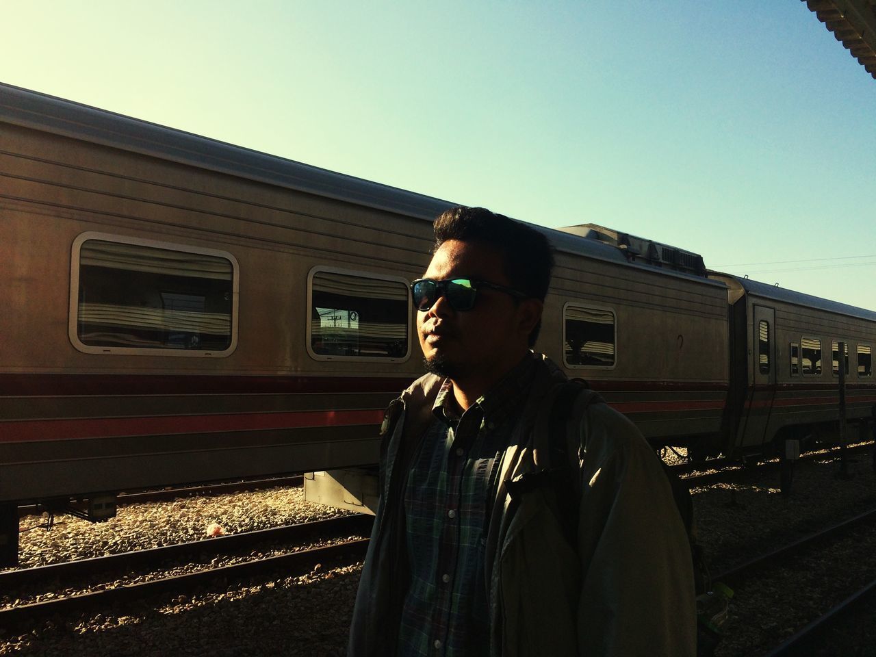 MAN STANDING ON TRAIN AGAINST SKY