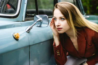 Beautiful woman looking herself on side-view car mirror