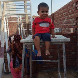 Full length of boy sitting outdoors