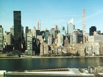 High angle view of river in city against blue sky