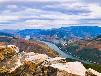 Scenic view of river by mountains against sky