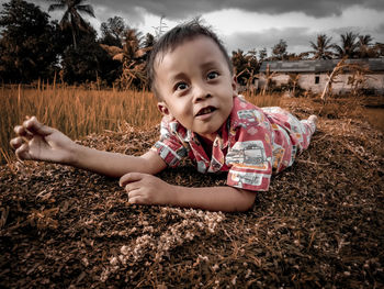 Portrait of cute girl lying on field