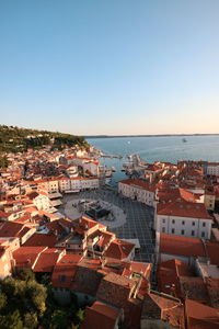 High angle view of townscape by sea against clear sky