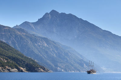 A cruise ship near the holy mountain - agion oros, athos, the summit and monasteries behind, greece