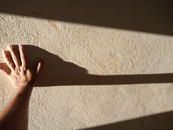 A hand on the wall illuminated by the sunlight