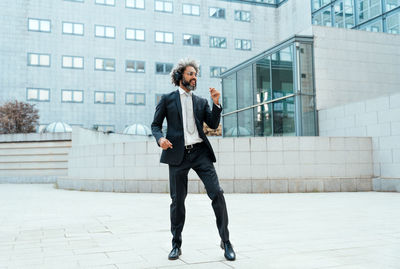 Portrait of young man standing against building