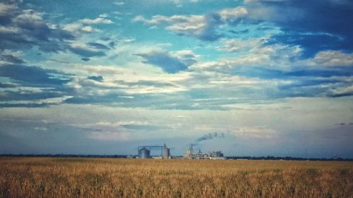 Scenic view of field against cloudy sky