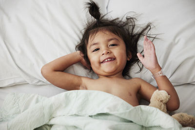 Smiling girl lying in hospital bed