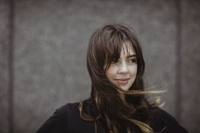 Smiling woman looking away while standing outdoors