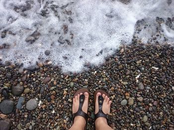 Low section of woman standing on pebbles