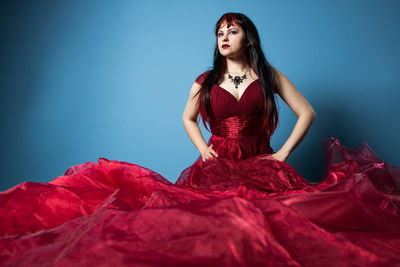 Portrait of a beautiful young woman against blue background