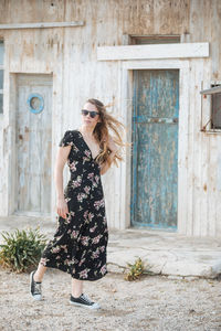 Full length of woman walking against old house