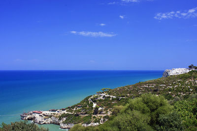 High angle view of coastline against blue sky