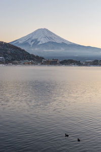 Scenic view of lake and snowcapped mountains against sky