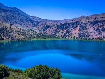 Scenic view of calm lake by mountain