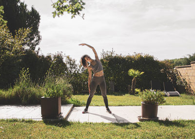 Side view of man jumping against plants