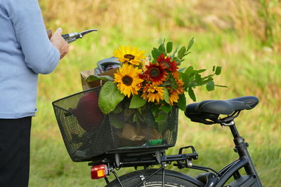 Close-up of hand with bicycle on yellow flower