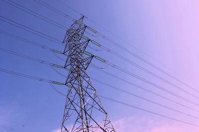 Low angle view of electricity pylon against sky during sunset