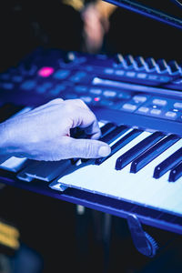 Cropped hand of man playing piano