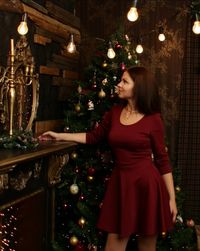 Woman in illuminated christmas tree