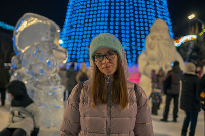 Portrait of young woman standing in city