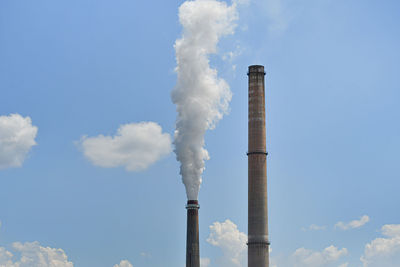 Low angle view of smoke stack against sky