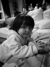 Portrait of cute girl standing by sofa at home