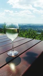 Wine glass on table against sky