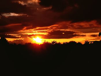 Scenic view of silhouette landscape against orange sky