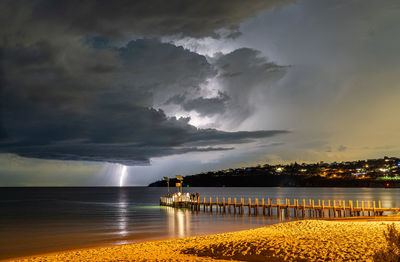 Lightning storm over harbour against moody cloudy sky
