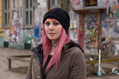 Portrait of young woman with pink hair standing on street