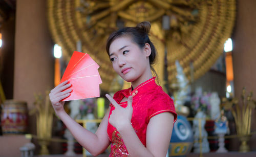Portrait of young woman holding envelopes