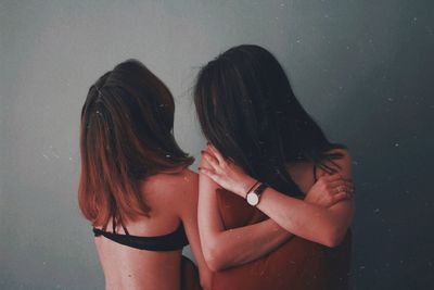 Friends standing against wall