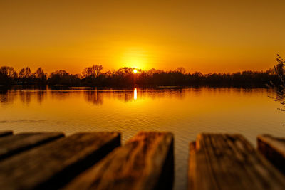 Scenic view of lake against orange sky