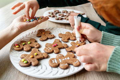 High angle view of mother with kids preparing cookies at home