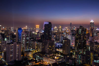 Illuminated cityscape against sky at night