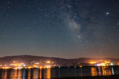 Scenic view of lake against sky at night