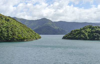 Scenic view of sea and mountains against sky