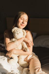 Portrait of young woman with teddy bear