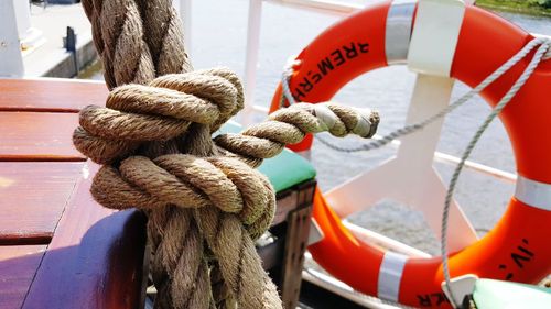 Close-up of rope tied to boat moored at harbor