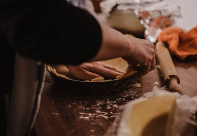 Midsection of person preparing food in kitchen