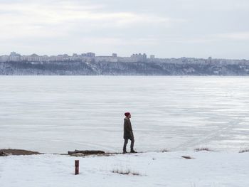 Side view of man standing on snow covered field