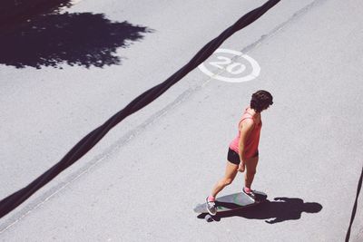 Full length of boy skateboarding on footpath