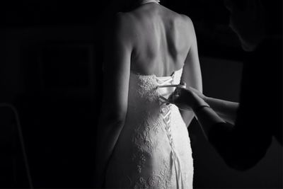 Woman helping bride in dressing