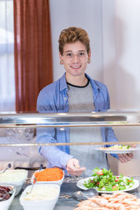 Portrait of smiling man standing in kitchen