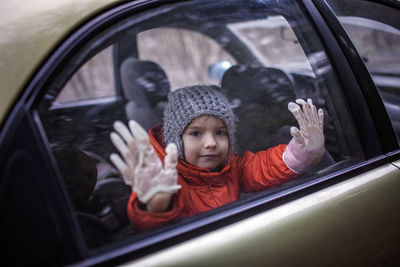 Portrait of boy looking through car window